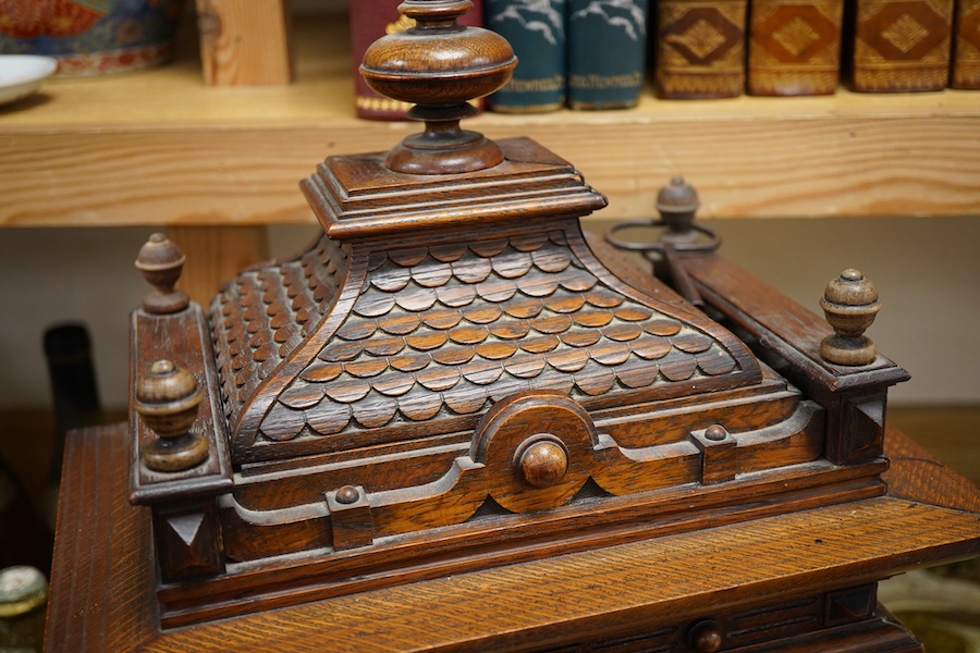 An early 20th century carved oak mantel clock, with key and pendulum, 58cm high